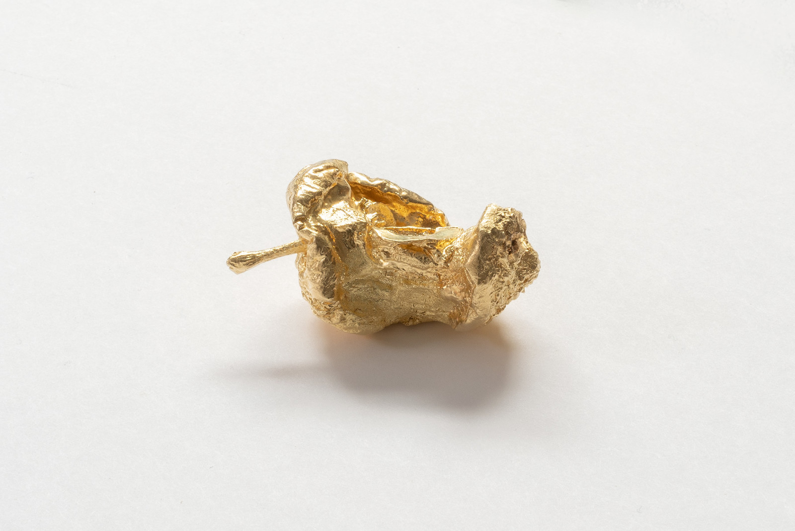 Half eaten apple jewelry laying horizontally on a white background