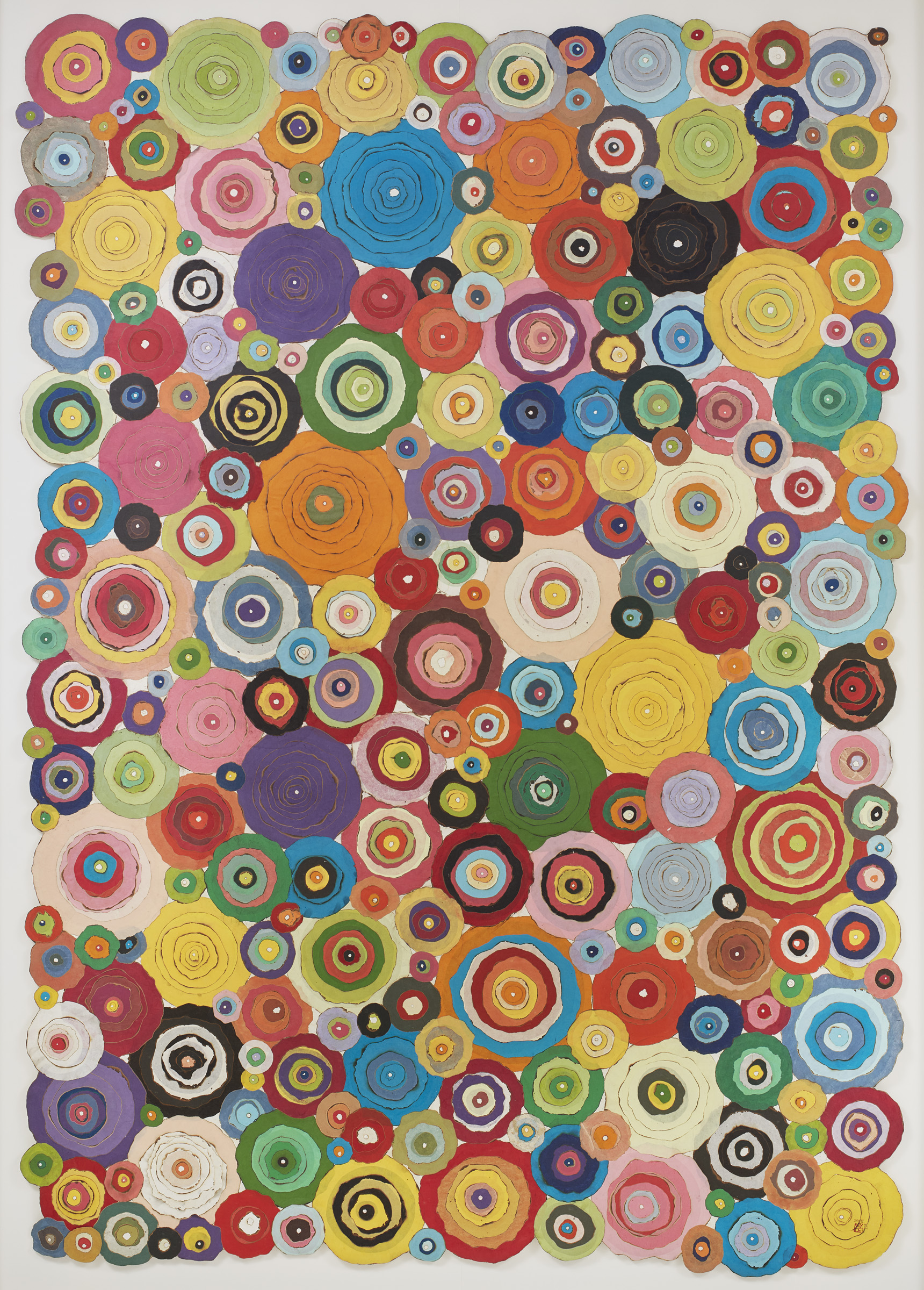 Numerous different colored circle shaped pieces of paper stacked to create a collage.