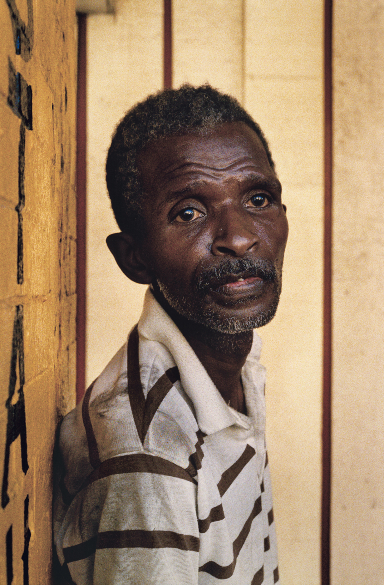 Photograph of an African American man in a striped polo shirt