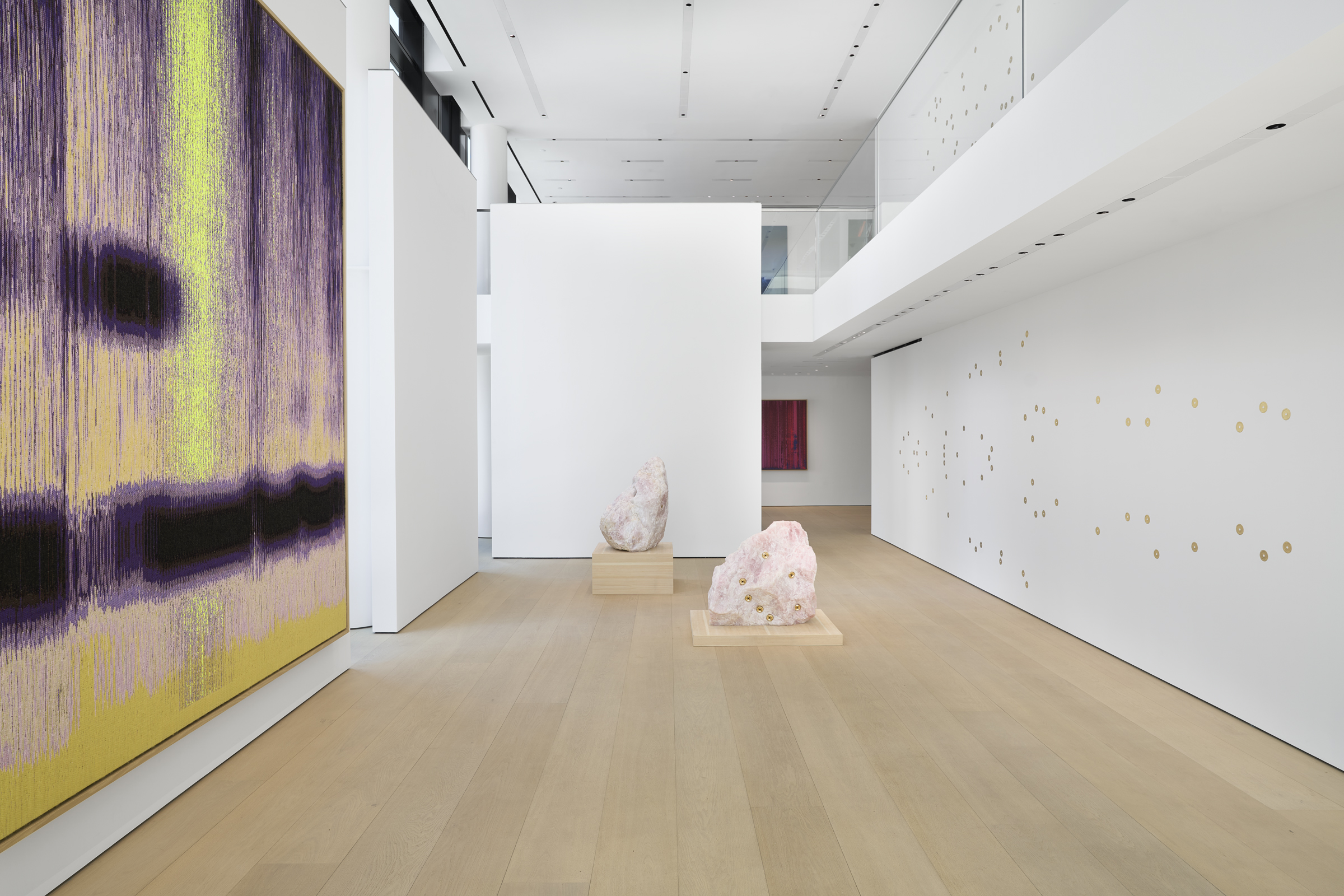 Two Rose Quartz sculptures with cast bronze jacuzzi jet nozzles on its surface placed on wooden...