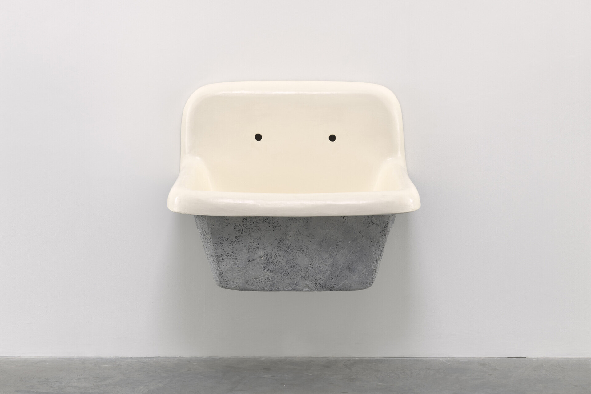 White and gray sink with missing faucets attached to a wall